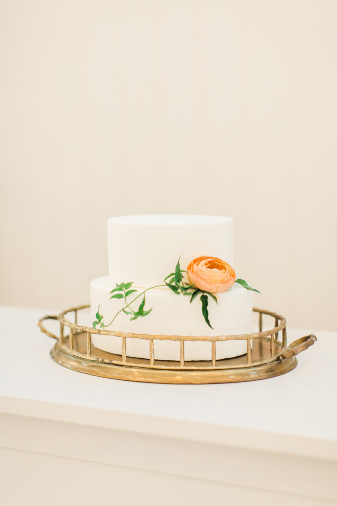 Modern Wedding Cake with White Icing and a Peach Flower with Minimal Greenery