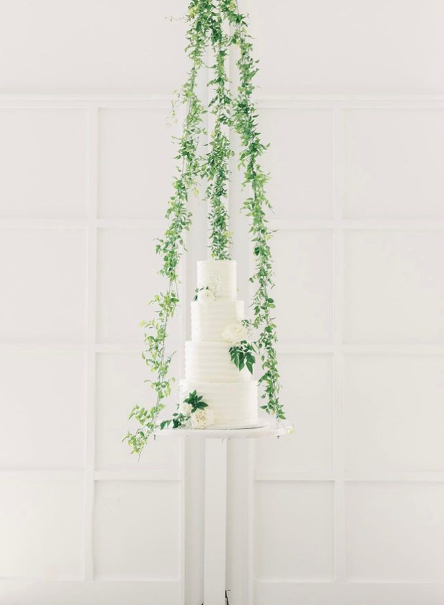 4 tier all white wedding cake with greenery